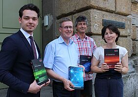Übergabe von Büchergeschenken an Prof. Matthias Laukner, Laboringenieur Michael Wallenta und Bibliotheksleiterin Astrid Schiemichen.