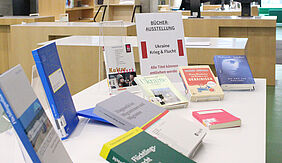 Bücher zu den Themen Ukraine und Krieg werden auf einem Tisch in der Bibliothek ausgestellt. 
