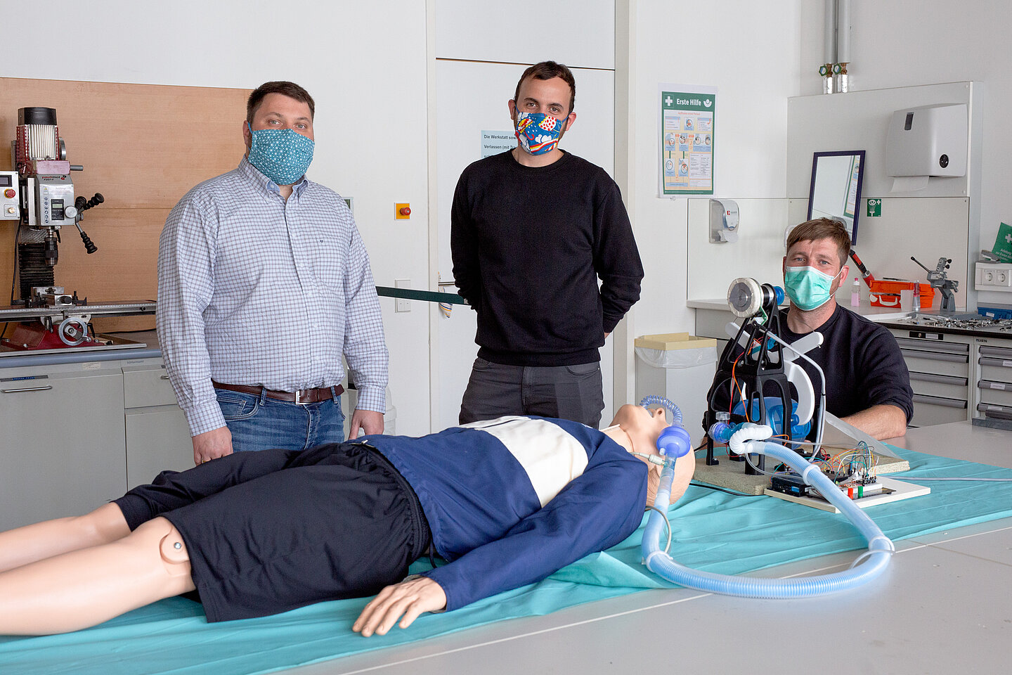 Dr. Hans-Martin Dörfler, Andreas Blum und Frank Schmidt vom Entwicklerteam Dr. Hans-Martin Dörfler, Andreas Blum und Frank Schmidt hinter einer medizinischen Puppe, die an das entwickelte Beatmungsgerät angeschlossen ist.