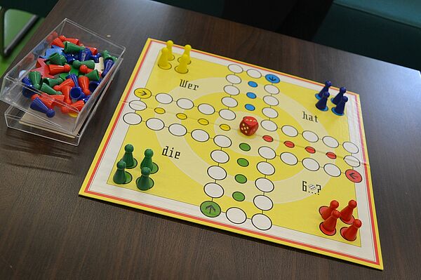 Ein aufbebautes und spielfertiges Mensch-ärgere-dich-nicht-Spiel auf einem Tisch