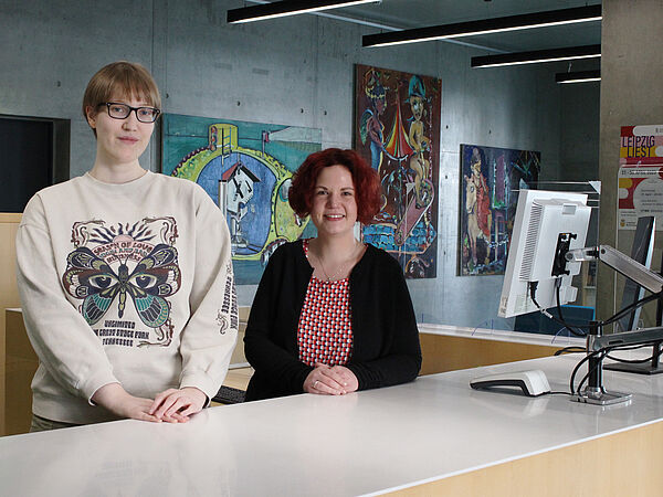 2 neue Bibliotheksmitarbeiterinnen an der Ausleihtheke.