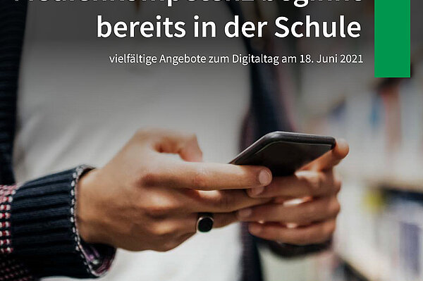 junger Mann hält vor einem Bücherregal ein Smartphone in der HandEin 