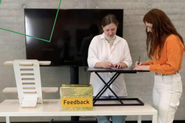 Zwei Studentinnen testen die mobilen Stehpulte in der Bibliothek.