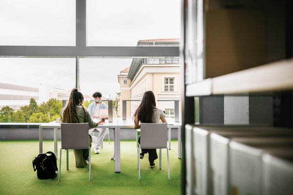 Nutzende der Bibliothek sitzen an Arbeitsplätzen mit Blick zur Karl-Liebknecht-Straße