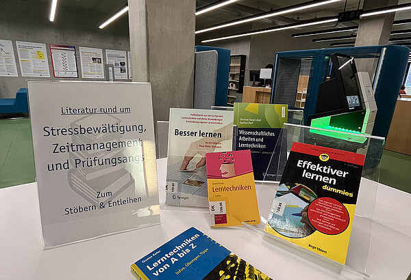 Ein Tisch mit Büchern aus dem Bibliotheksbestand und dem Hinweis, dass alle entleihbar sind. Thematisiert werden vor allem Lernstrategien.